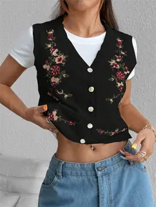 Gros plan sur la broderie florale d'un gilet en maille noir boutonné de style bohème