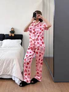 Ensemble de pyjama en satin à imprimé cœur pour femme dans un décor de chambre cosy
