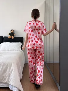 Vue arrière d'un ensemble pyjama rose à motif cœurs pour femme avec haut court et pantalon