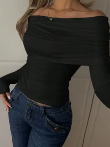 Primo piano di un top nero aderente a spalle scoperte con eleganti dettagli drappeggiati.