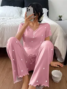 Close-up of pink ribbed pajama set with cute heart prints and stylish ruffled edges.