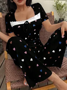 Close-up detail of a stylish women's black heart print pajama set with white lace trim