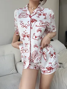 Detailed close-up of women's white satin pajama set with romantic red heart and envelope prints