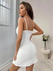 Side view of white ribbed camisole dress with open back and delicate lettuce hem detailing