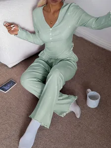 Modèle portant un ensemble de pyjama côtelé vert clair à motif cœur dans un intérieur