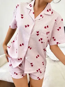 Detail view of women's pink striped pajama set with red heart patterns and buttons.
