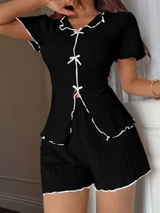 Elegant black two-piece pajama set featuring white bow details and contrast piping trim