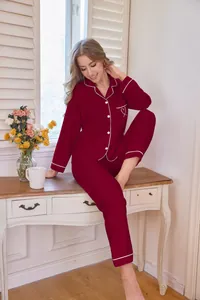 Elegantes rotes Damen-Pyjama-Set mit weißer Paspelierung und Herzstickerei auf der Tasche.