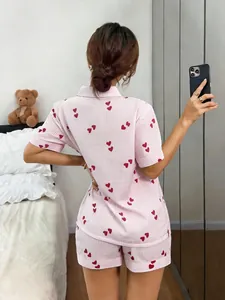 Back view of women's pink heart print pinstripe short sleeve pajama set shown in a mirror