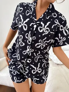 Nahaufnahme des stilvollen dunkelblauen Damenpyjamas mit weißem Schleifen-Stern-Muster