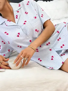 Close-up detail of women's short-sleeved striped pajama set with red heart patterns