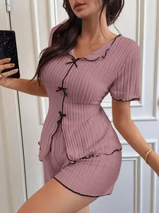 Detailed view of the mauve ribbed pajama set featuring bows and chic black trim