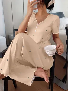 Detailed view of women's cream ribbed pajama set with tiny heart prints in a cozy home setting