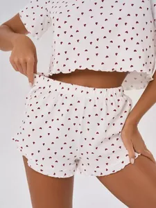Detailed view of women's 100% cotton pajama set with red heart print and lettuce trim