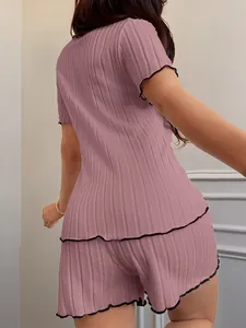 Detailed back view of pink ribbed short sleeve pajama set featuring elegant black ruffled edges