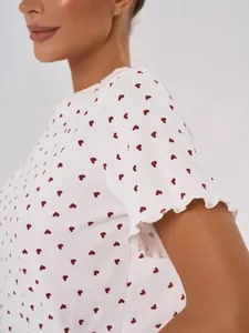 Close-up detail of cotton pajama top with red heart prints and lettuce edge sleeves