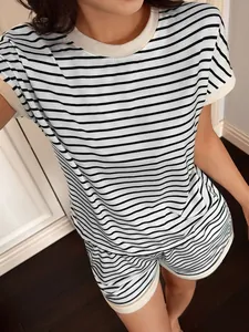 Dettaglio del set casual da donna con maglietta a maniche corte a righe bianche e nere e pantaloncini.