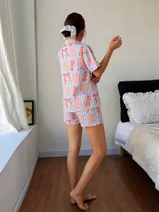 Rückansicht einer Frau in einem süßen gestreiften Pyjama-Set mit Hasenprint im Schlafzimmer