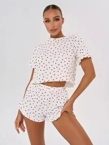 Two-piece women's cotton pajama set with red heart print and ruffled hems on model