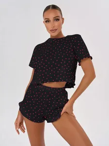 Detail view of women's black 100% cotton pajama set featuring red heart prints