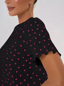 Close-up of a women's cotton pajama top with pink heart prints and ruffled sleeves