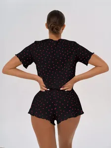 Back view of black cotton pajama set featuring red heart print and delicate ruffled hems.