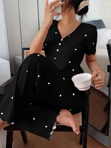 Woman wearing a stylish black ribbed pajama set with white heart patterns