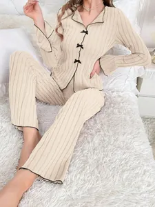 Detailed view of beige ribbed loungewear set featuring black bow and piping accents