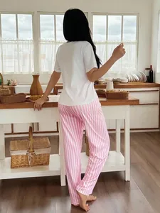 Πίσω όψη ενός casual γυναικείου σετ πιτζάμας με λευκό μπλουζάκι και ροζ ριγέ παντελόνι