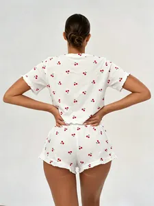 Rear view of model wearing a white 100% cotton two-piece pajama set with cherry print