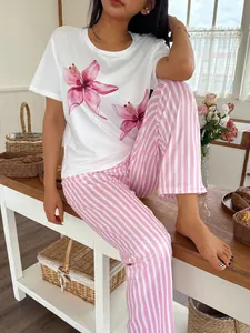 Γυναικείο σετ πυτζάμας με λευκό φλοράλ T-shirt και ροζ ριγέ παντελόνι στον οικιακό χώρο