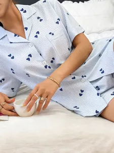 Detailed view of blue striped pajama set with dark heart patterns and lapel collar.