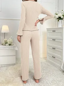 Back view of beige ribbed loungewear set with elegant black contrast piping details