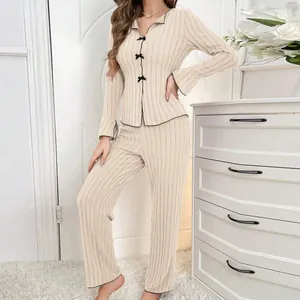 Elegant women's beige ribbed two-piece pajama set with delicate black bow details