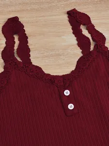 Gros plan d'un débardeur côtelé bordeaux avec bordure en dentelle et boutons.