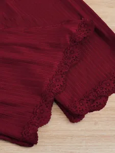 Gros plan sur la dentelle bordeaux élégante du tissu d'un ensemble pyjama