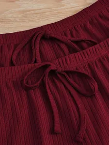 Vue rapprochée du tissu côtelé bordeaux du pyjama et du cordon de serrage à la taille