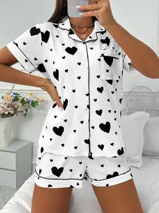 Detailed view of women's white heart print pajama set with black piping and buttons