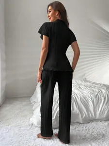Vista posteriore dettagliata di un set pigiama in maglia nera con tessuto strutturato.
