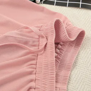Close-up detail showing pink ribbed knit fabric and elastic waistband of loungewear