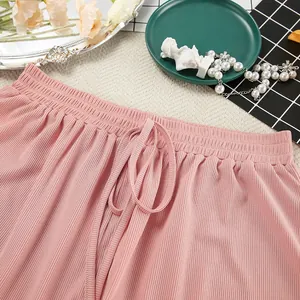 Close-up of pink ribbed knit loungewear shorts showing drawstring waistband and fabric texture.