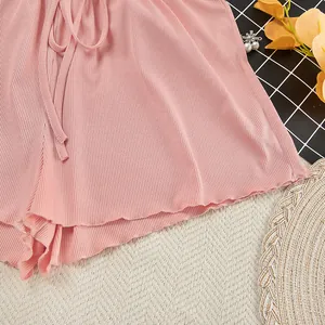 Close-up view of pink ribbed knit loungewear shorts with ruffle hem and drawstring