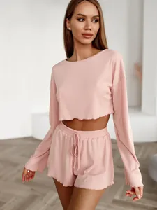 Detailed view of women's pink ribbed knit loungewear set featuring crop top and shorts