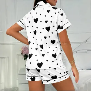Two-piece white women's pajama set featuring black heart patterns and short sleeves.