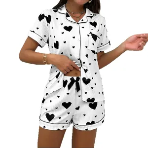 Elegant women's heart print pajama set with short sleeve shirt and matching shorts.