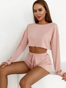 Detailed view of a soft pink ribbed two-piece lounge set with a crop top and shorts