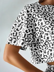 Detail shot of leopard print pajama top with ribbed fabric texture and white background.