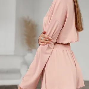 Women's pink ribbed knit two-piece lounge set with cropped long sleeve top and shorts