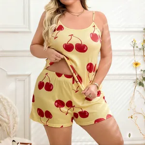 Detailed view of yellow satin pajama set featuring vibrant red cherry prints and camisole top