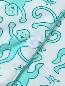 Detailansicht des Affen-Prints und des weißen Knopfes auf weichem Pyjama-Stoff.